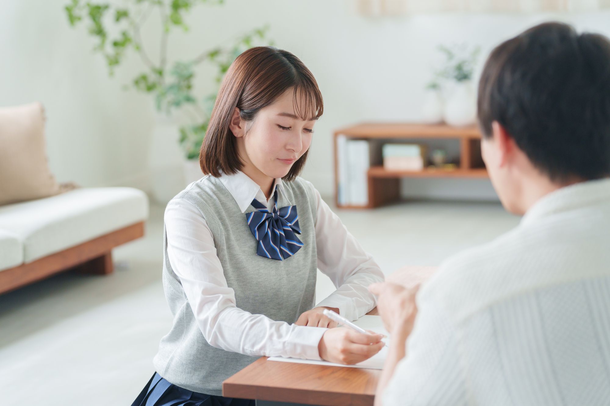 部屋で彼氏と勉強する女子学生