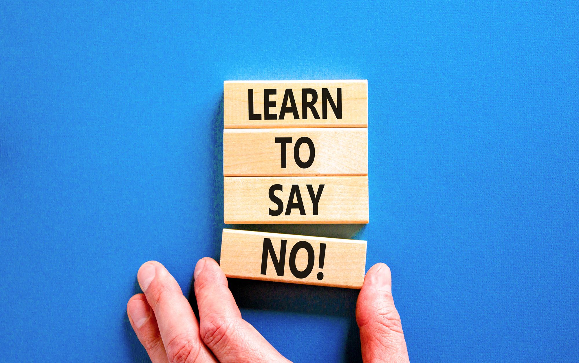 LEARN TO SAY NO！と書いた積み木をもつ手
