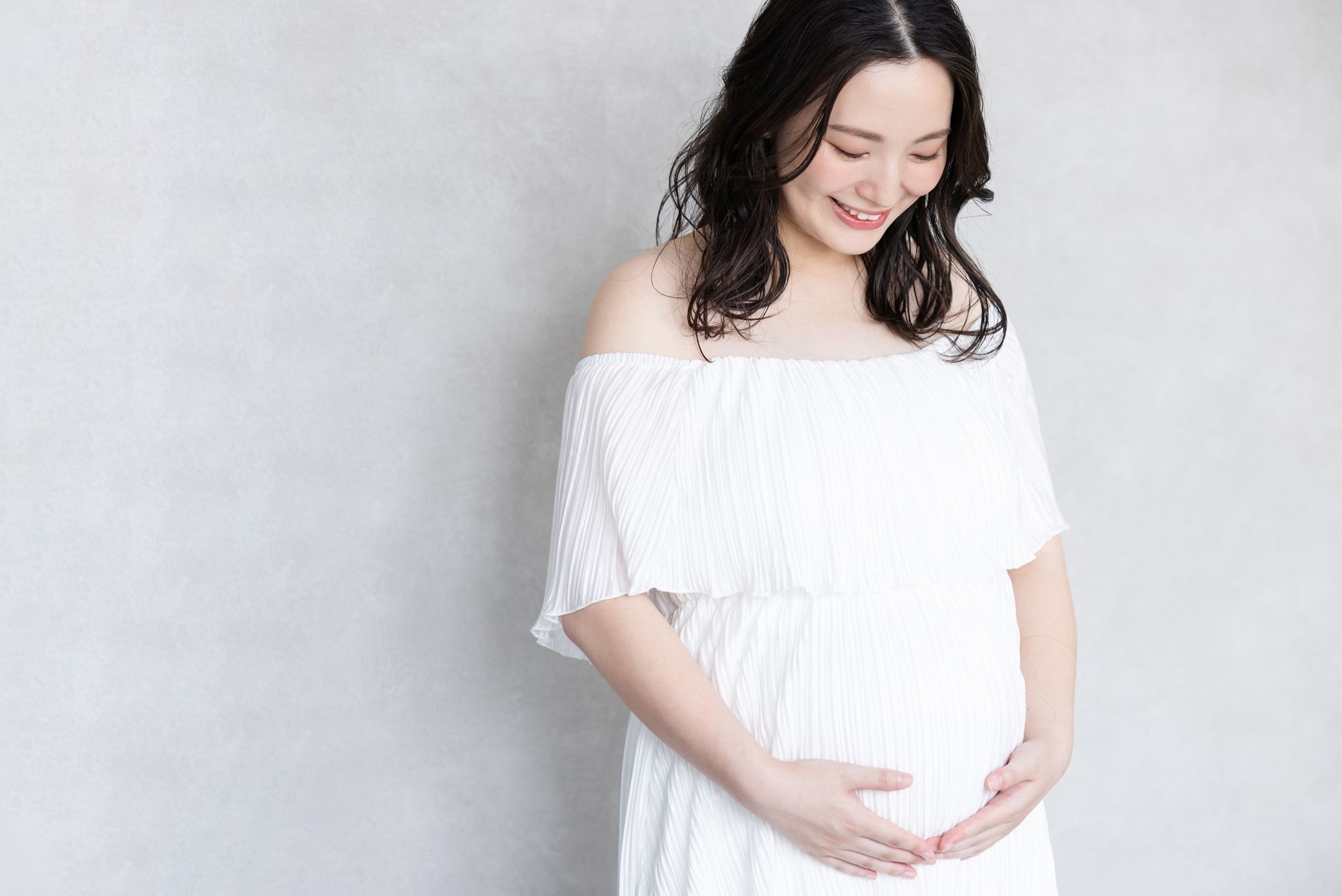 優しい顔でお腹を見つめる妊婦さん