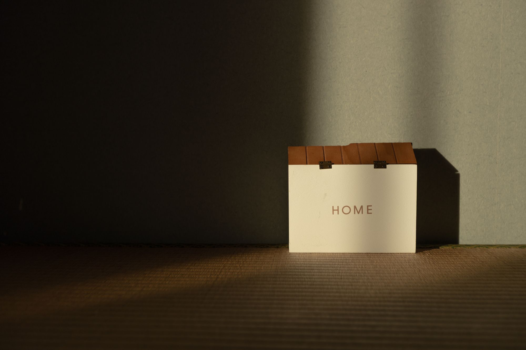 夕暮れの光がさす「HOME」と書かれた家の模型