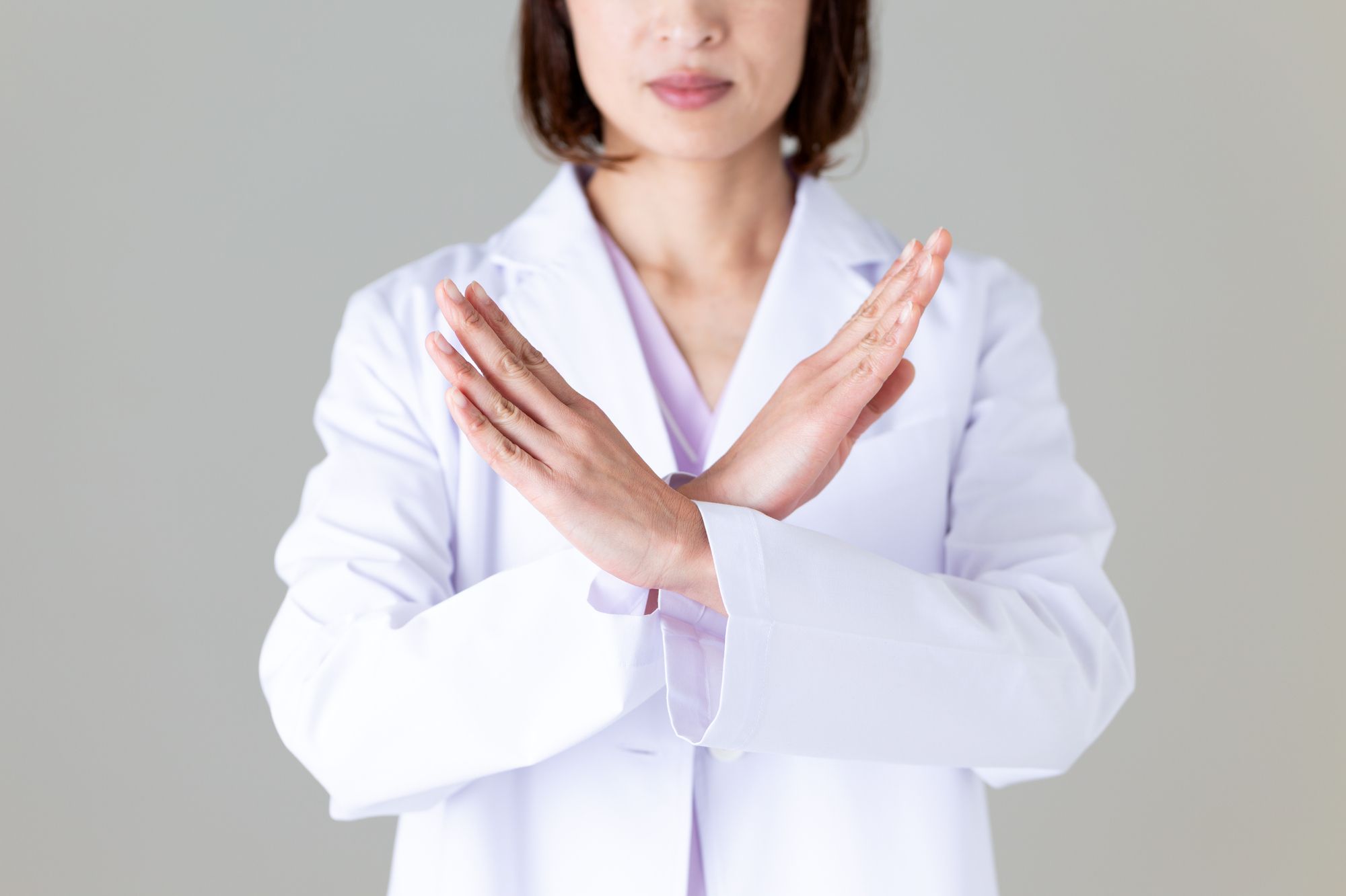 胸の前でバツを作る女性医師
