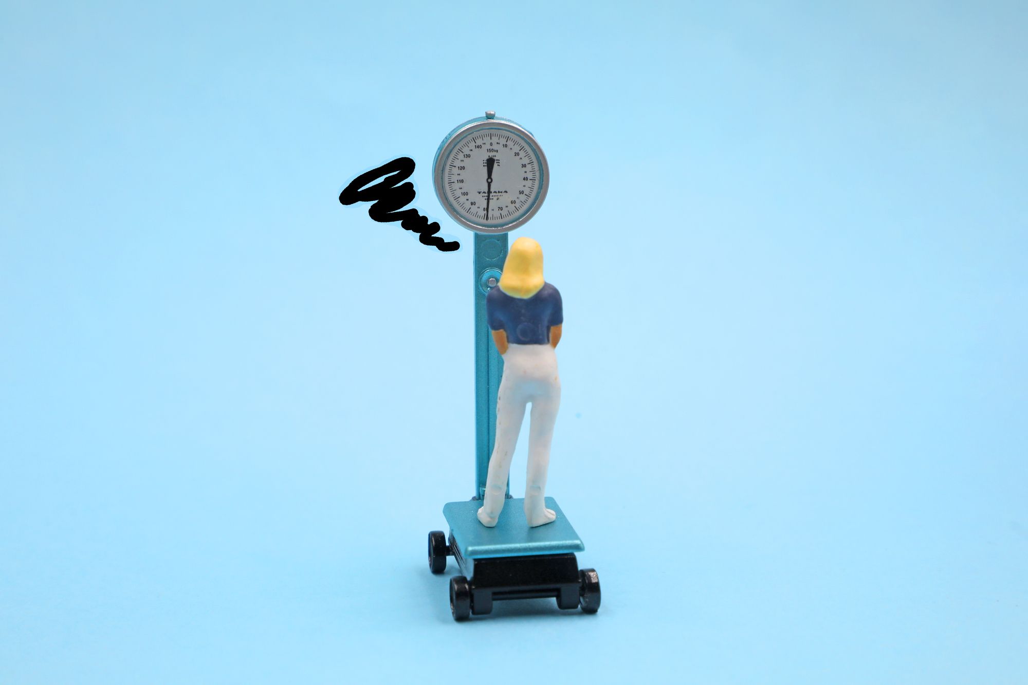 体重計に乗って体重の増加を気にする女性