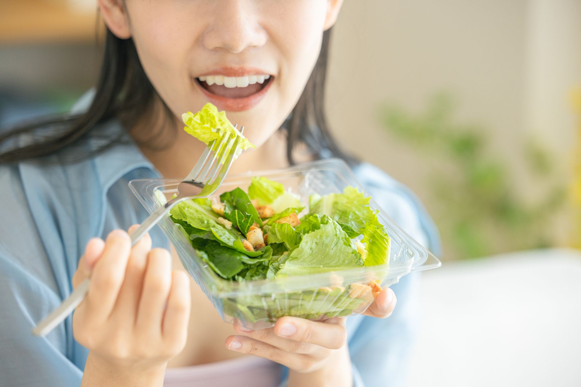 美味しそうにサラダを食べる女性