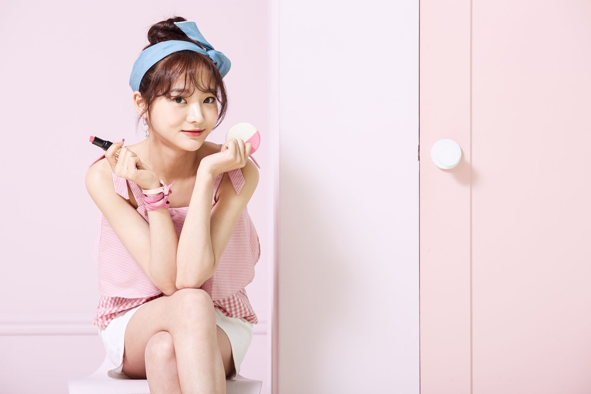 メイク用品を持って座る女性