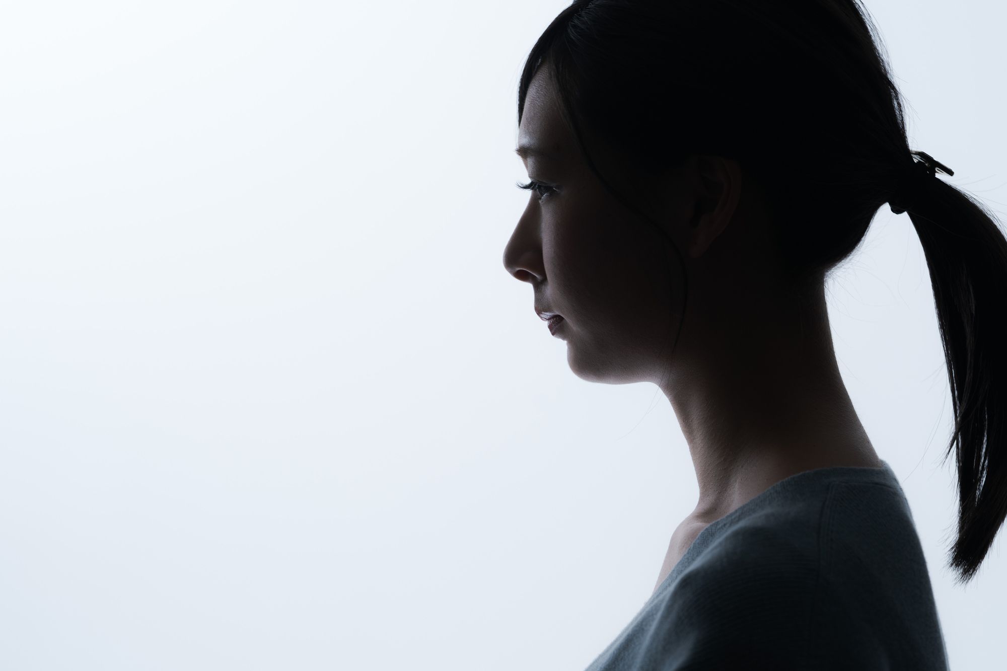真顔で黙り込む若い女性の横顔
