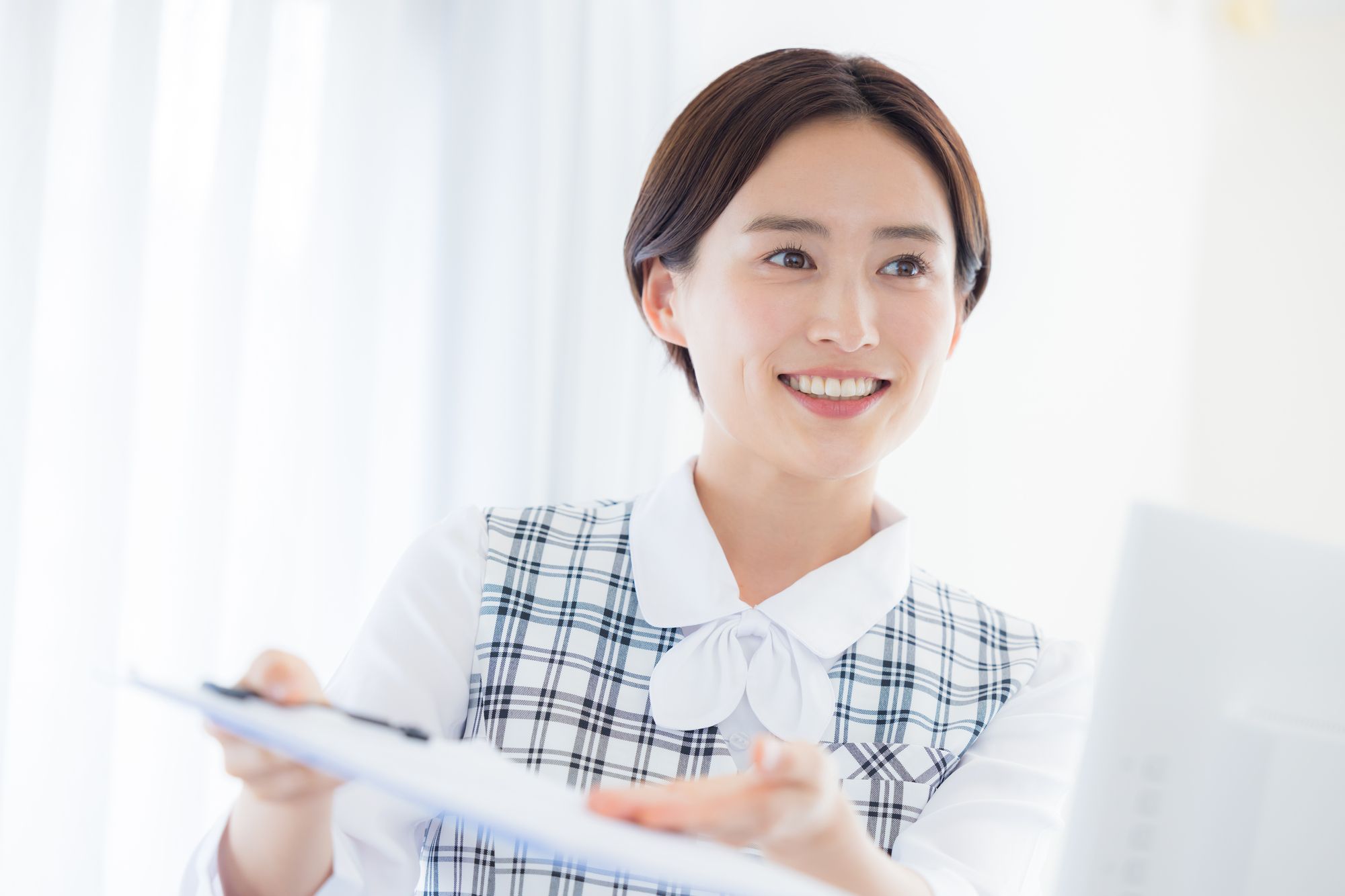 笑顔で受付業務をする女性スタッフ